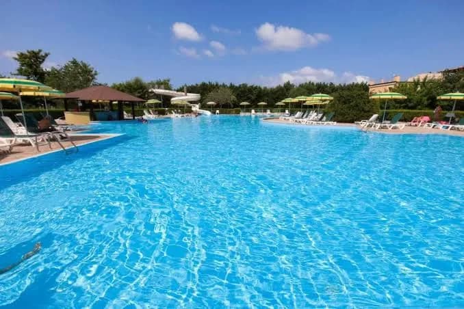 Piscina del Pizzo Beach Club con ombrelloni e, sullo sfondo, uno scivolo
